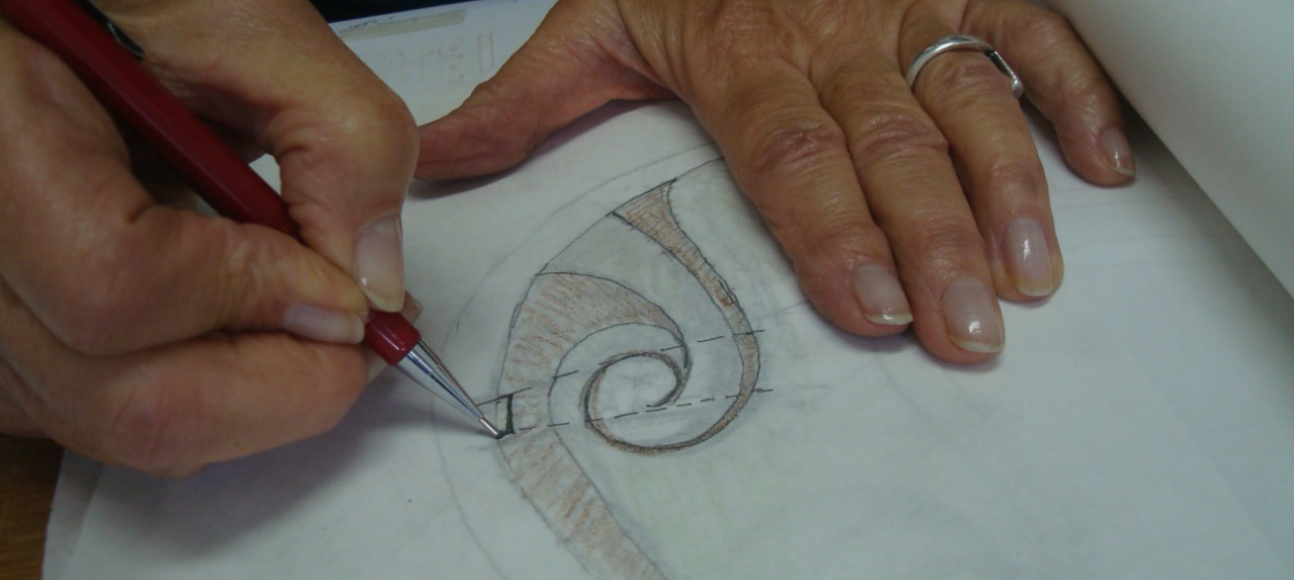 Rosa Kliass desenhando uma forma sobre uma folha em branco no seu escritório.